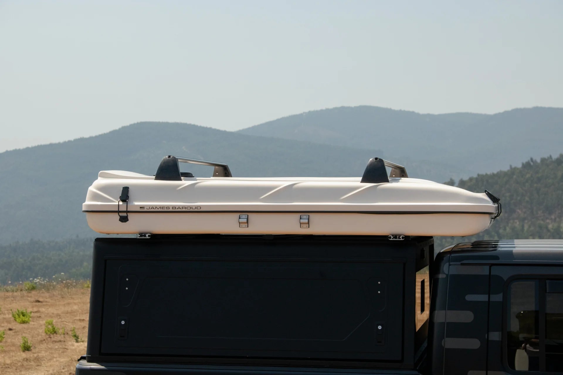Roof top tent attached to a vehicle with mountains in the background