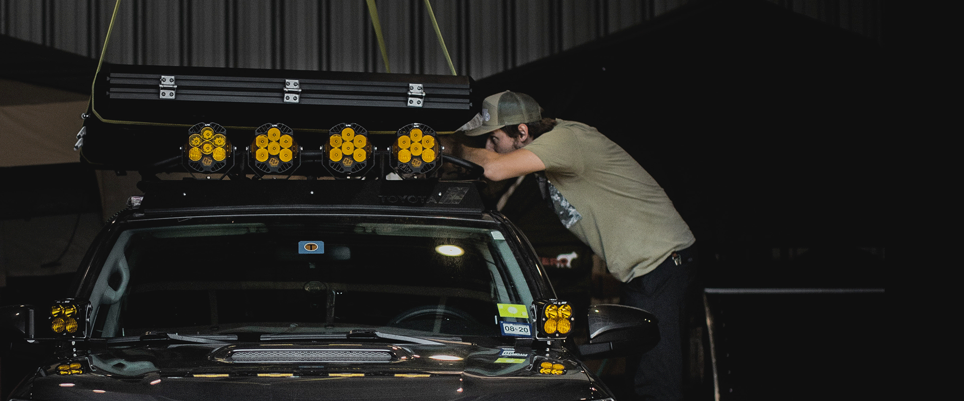 a man and roof top tent being install on 4runner