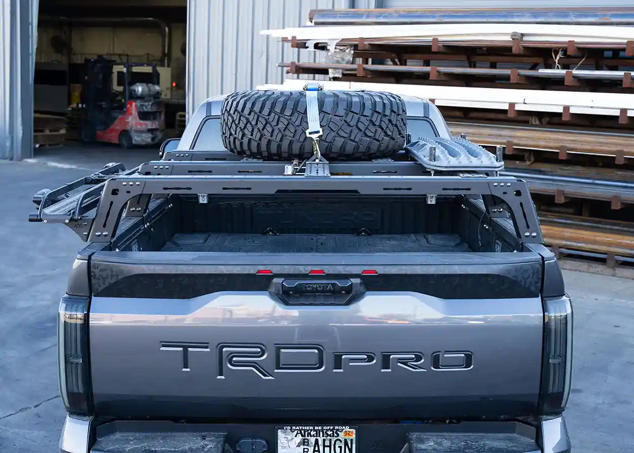 Gray Toyota TRD Pro truck with a tire on a rack in a warehouse setting