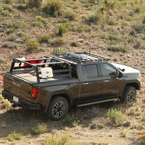 GMC Denali Sierra Extrusion Overland Bed Rack with RotoPax, WeBoost antenna, overlanding gear, traction boards, Retrax XR tonneau cover, and Off-road lights.