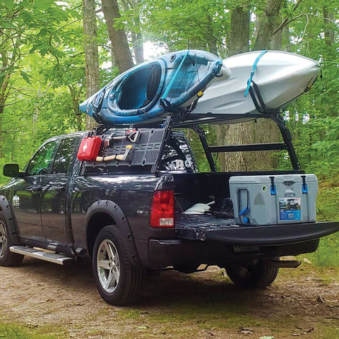 Dodge Ram Extrusion Overland bed rack with Molle panels, shovel, ax, and canoes mounted to top of bed rack.