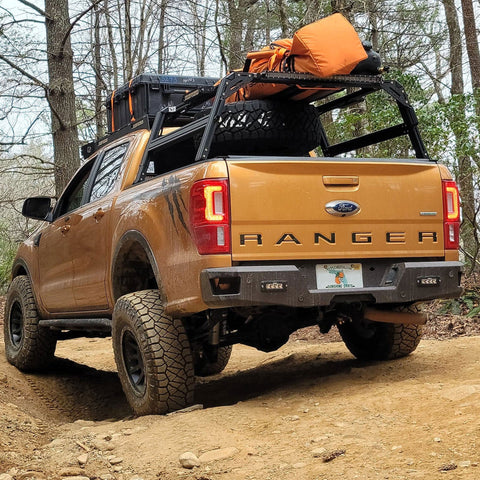 Ford Ranger with extrusion bed rack with spare tire and gear.