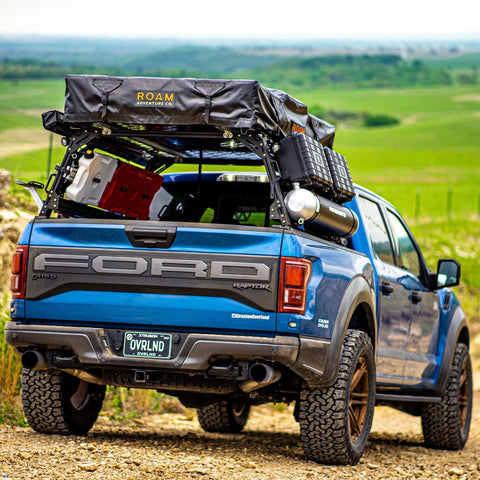Gen 2 Ford Raptor Extrusion Overland Bed Rack with Rotopaxâ€™s mounted, Molle panels, Roof top tent, awning, travel cases, and Pressurized solar water tank.